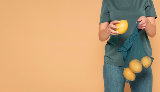 Close up woman holding turtle bag with lemons
