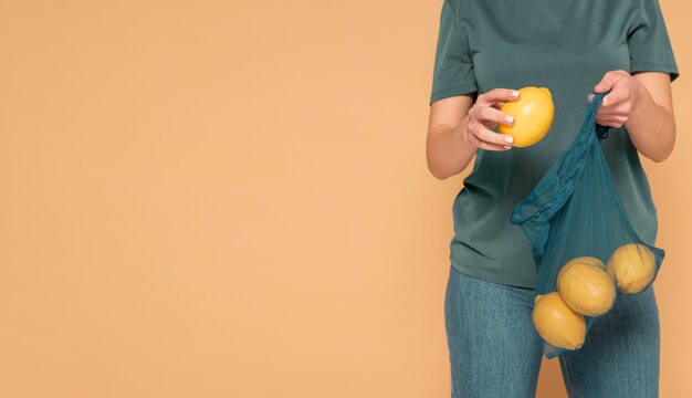 Close up woman holding turtle bag with lemons