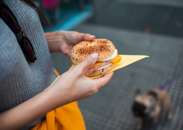 ハンバーガーを保持しているクローズアップの女性