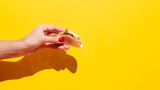 Close-up woman holding up delicious taco