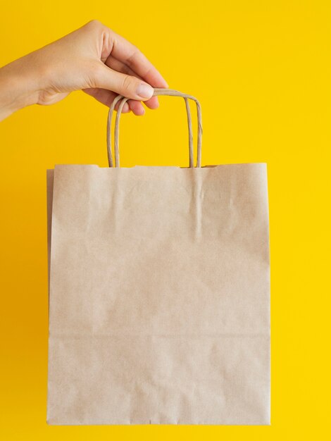 Close-up woman holding up paper bag