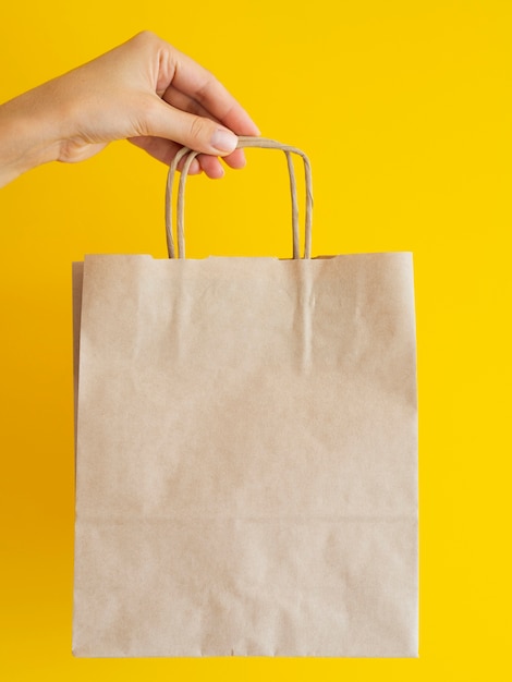 Close-up woman holding up paper bag