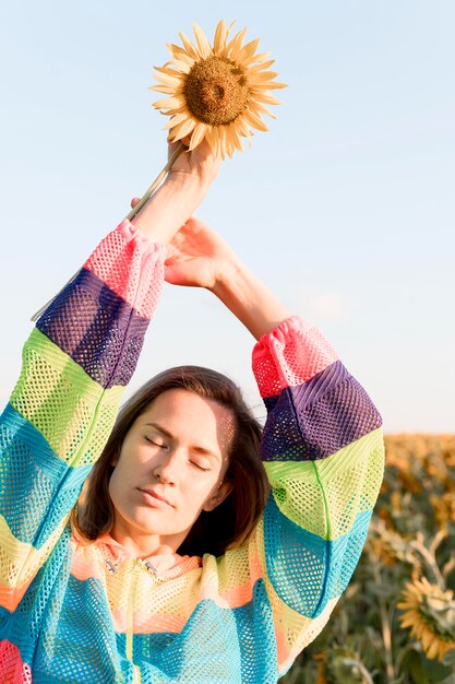 Close-up woman holding up sunflower