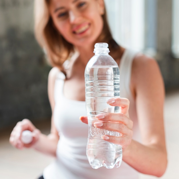 水のボトルを保持しているクローズアップの女性