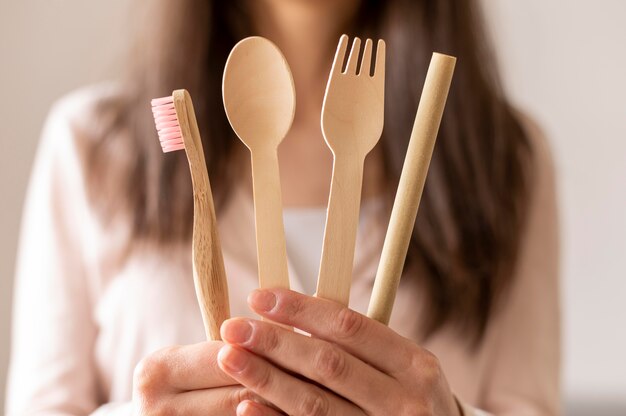 close-up woman holding wooden cutlery