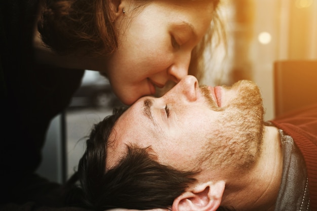 Close-up of woman kissing her boyfriend's face