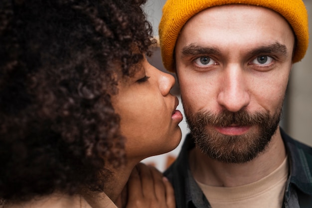 Free photo close-up woman kissing hipster man