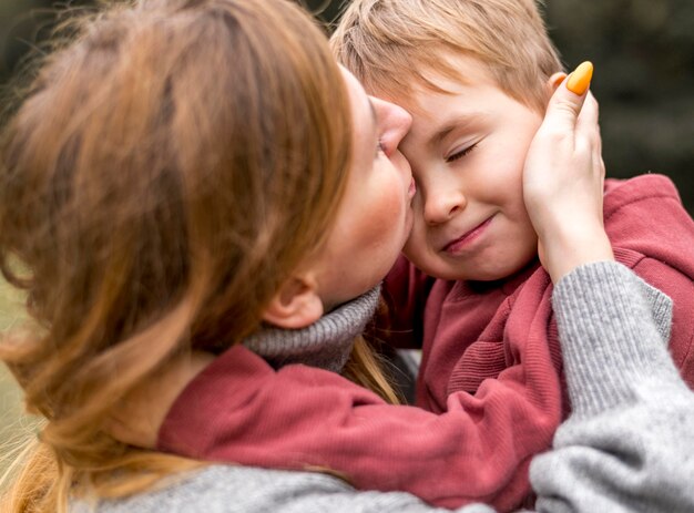 close-up woman kissing son