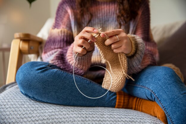 家で編み物をしている女性をクローズアップ