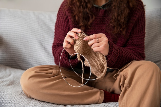 ソファで編み物をする女性をクローズアップ