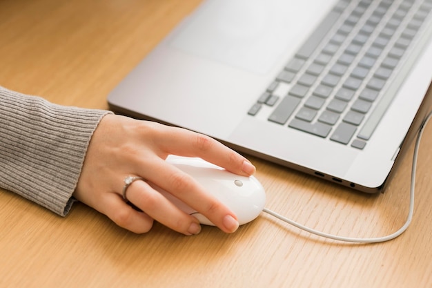 Крупным планом женщина на ноутбуке с помощью мыши