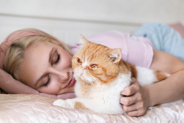 かわいい猫と一緒に横たわっている女性をクローズアップ