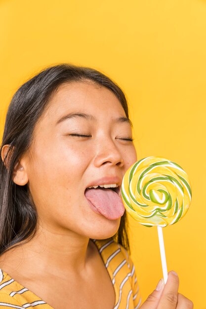 Close-up woman licking a lollipop 