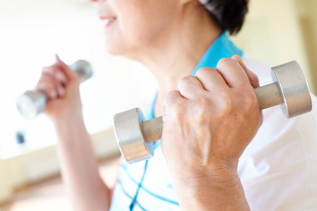 Close-up of woman lifting dumbbells