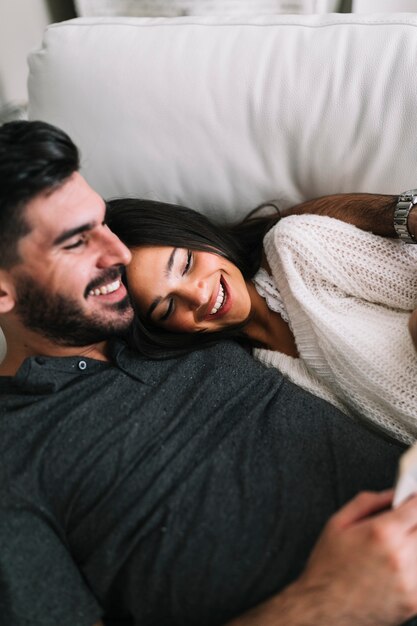 Foto gratuita primo piano della donna che si trova con l'uomo sorridente sul sofà