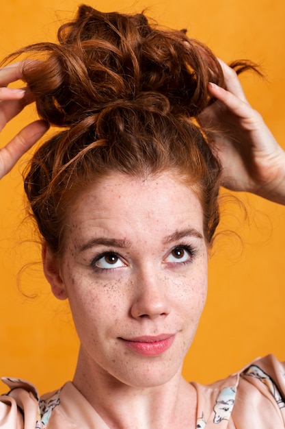 Free photo close-up woman making a hair bun
