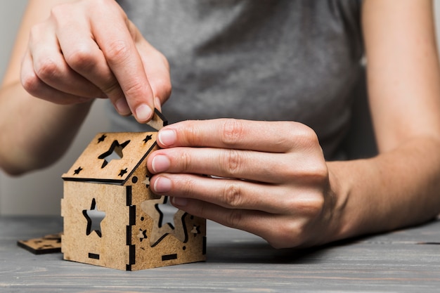 Close-up of woman making handmade house on table