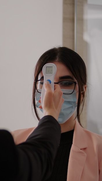 Close up of woman measuring temperature with medical thermometer to prevent covid 19