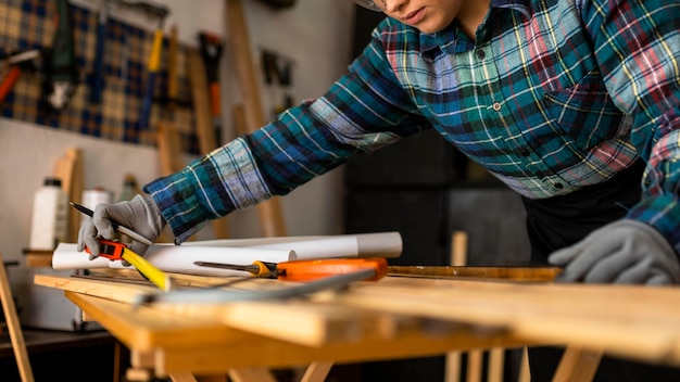 Free photo close up woman measuring wood plank