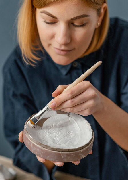 Close-up woman painting clay