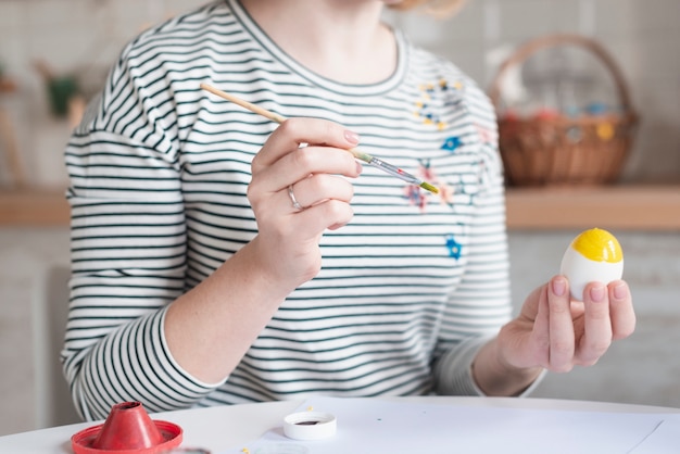 Close-up woman painting egg for easter