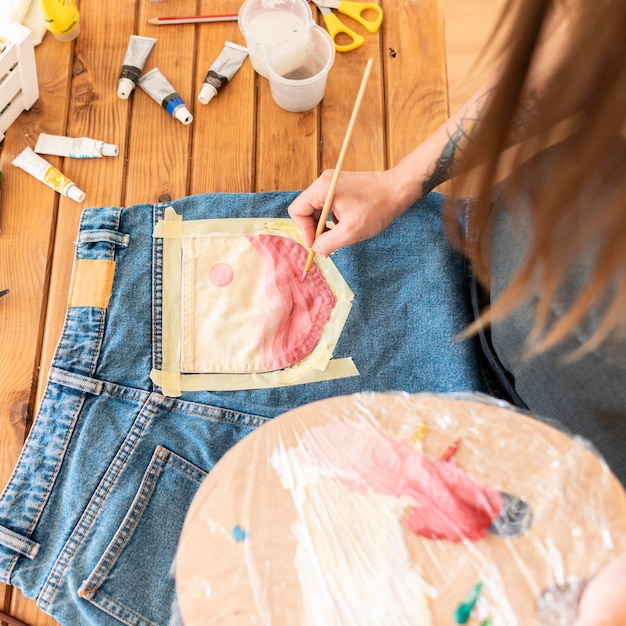 Close-up woman painting jeans