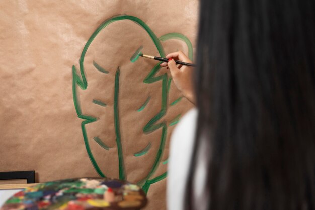 Close-up woman painting leaf