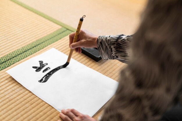 Close-up woman painting letter