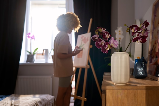 Foto gratuita primo piano sulla donna che dipinge orchidee