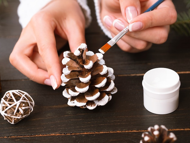 Close-up of woman painting pine cone