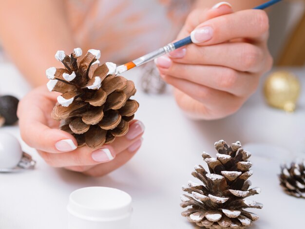 Close-up of woman painting pine cones