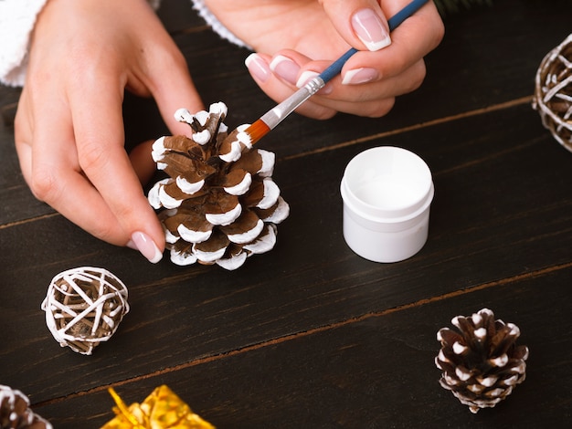 Close-up of woman painting pine cones