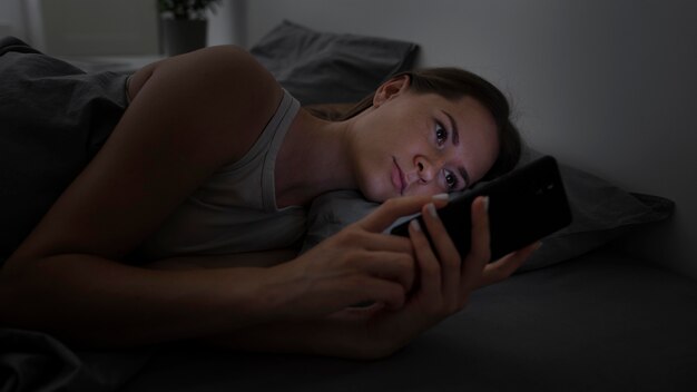 Free photo close up on woman on phone in bedroom