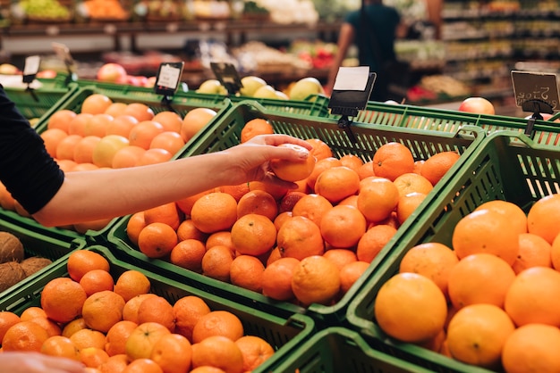 Close-up woman picking up a clementine