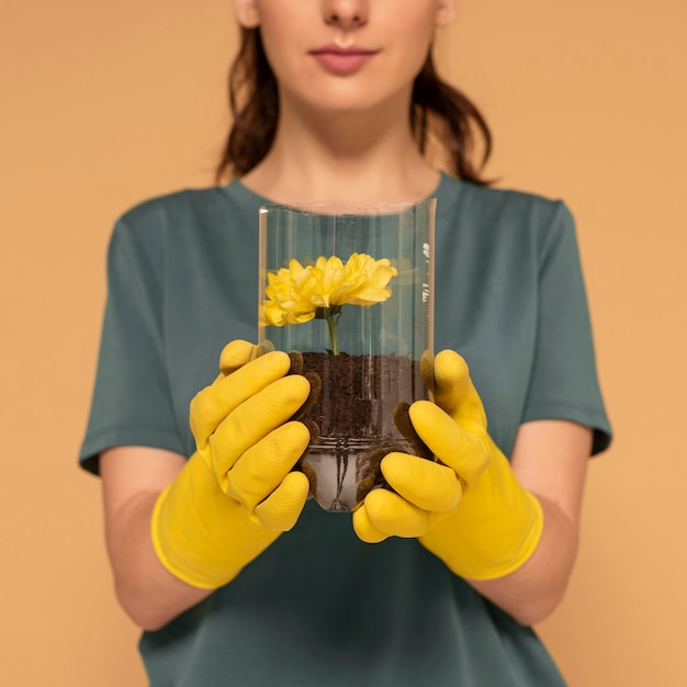 Foto gratuita close up donna piantato fiore in bottiglia di plastica