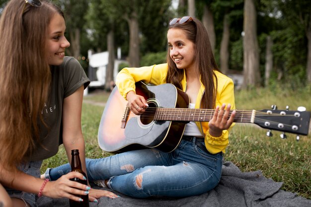 Close up woman playing the guitar outdoors