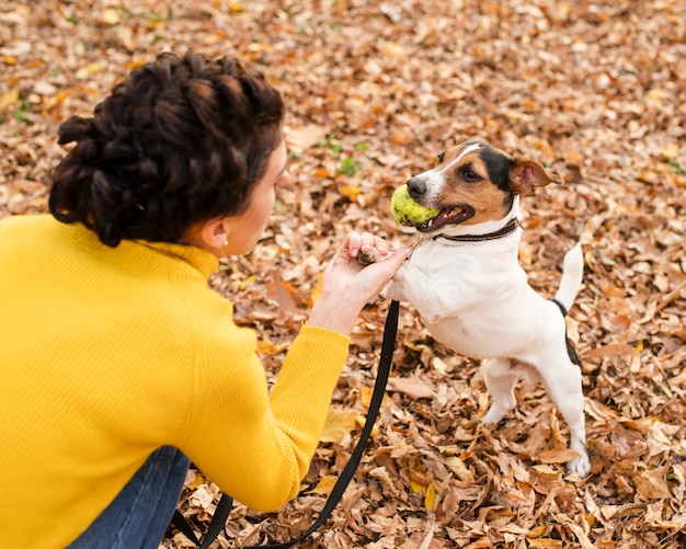 Close-up woman playing with her puppy