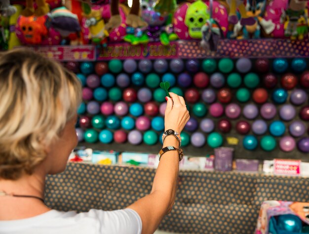 Close-up woman popping balloons