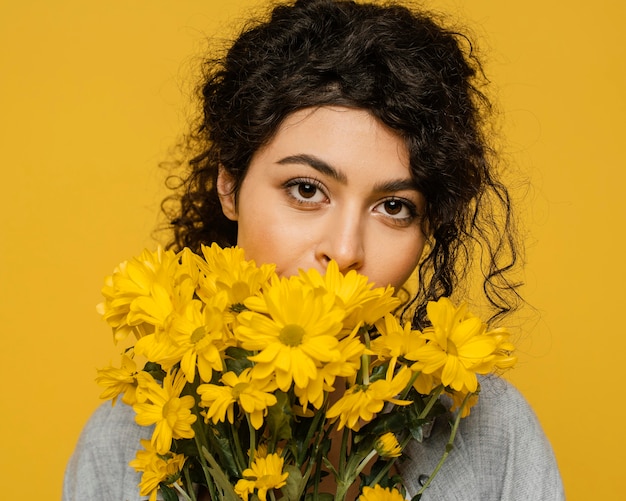 Donna del primo piano che posa con i fiori