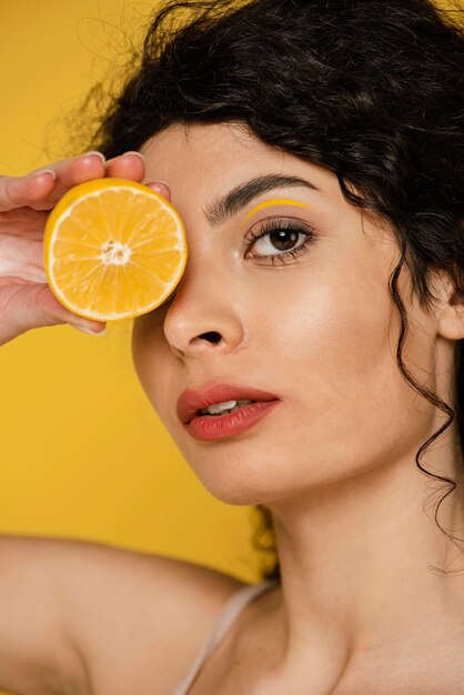 Close-up woman posing with lemon slice