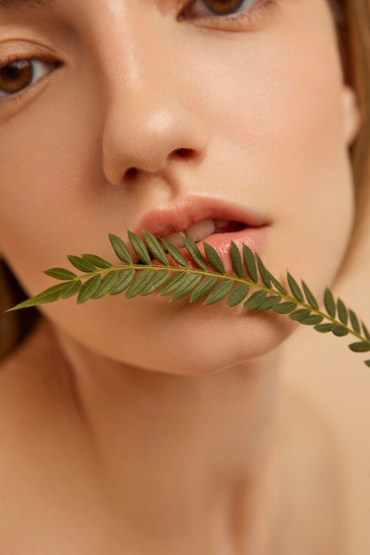 Foto gratuita chiuda sulla donna che posa con la pianta