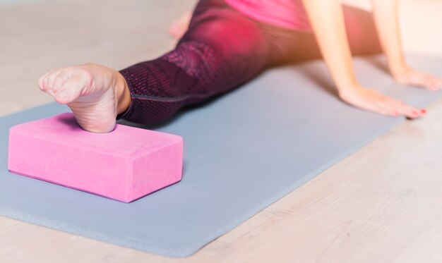 Close-up of a woman practicing yoga using yoga block