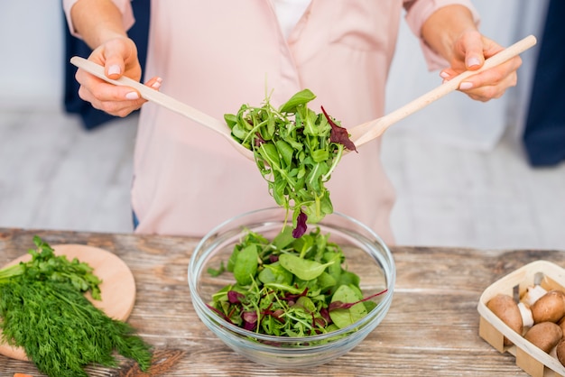 Close-up of woman preparing the leafy vegetable salad