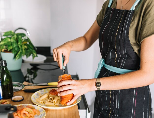 Close-up of woman preparing pasta in the kitchen