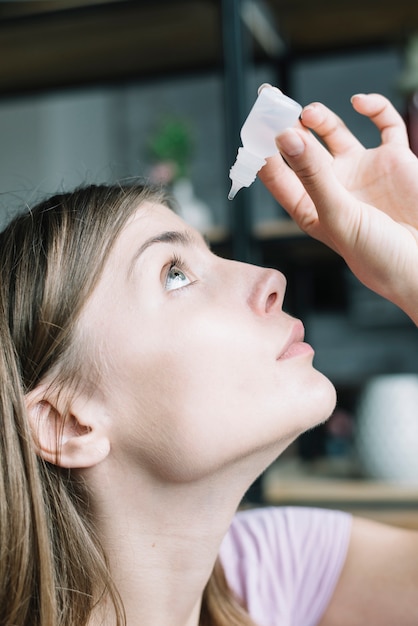 Close-up of a woman putting eye drops