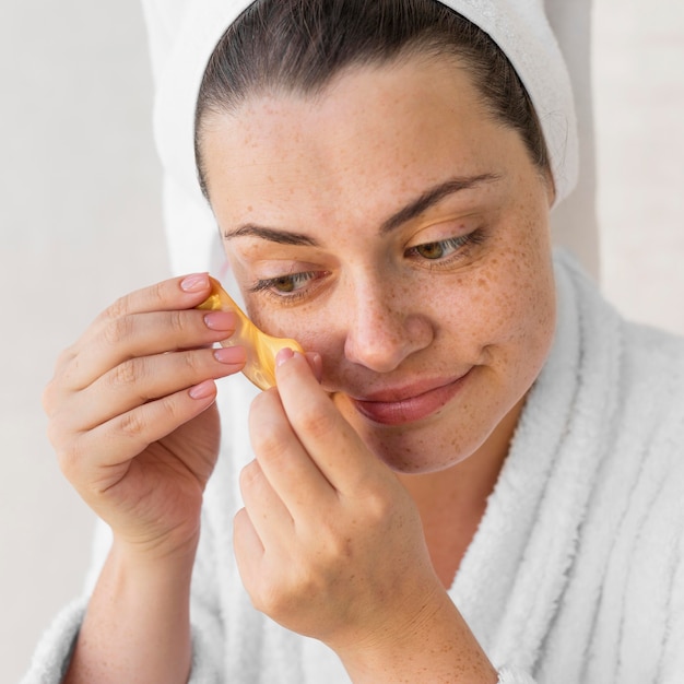 Free photo close-up woman putting on eye patch