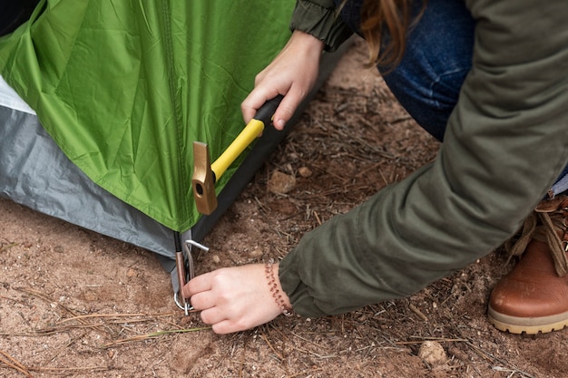 Free photo close-up woman putting up a tent