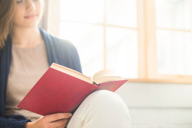 Close-up of a woman reading book at home