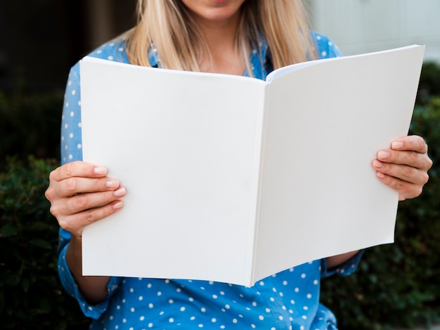 Free photo close-up woman reading a mock-up magazine