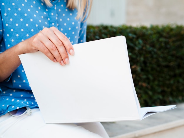 Free photo close-up woman reading a mock-up magazine